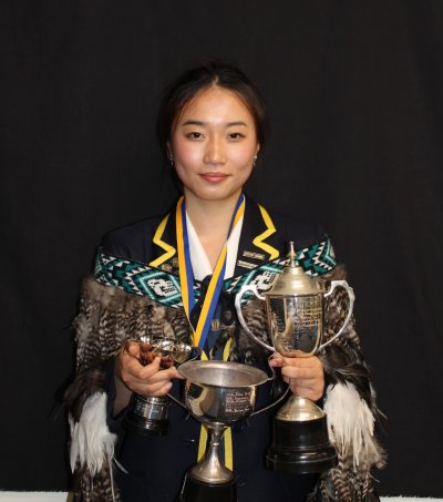 A photo of Yilin holding her Year 13 awards