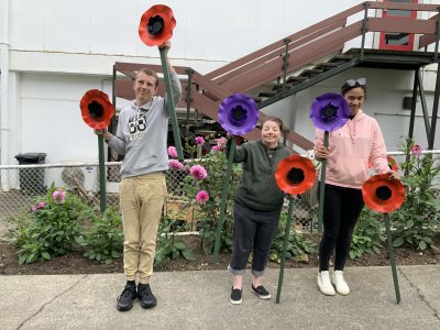 The Shed Project Members holding the poppies they've made